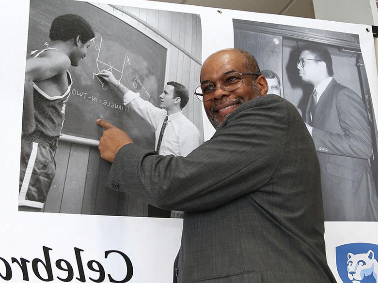 An alum pointing to his picture from when he was a student on the basketball team